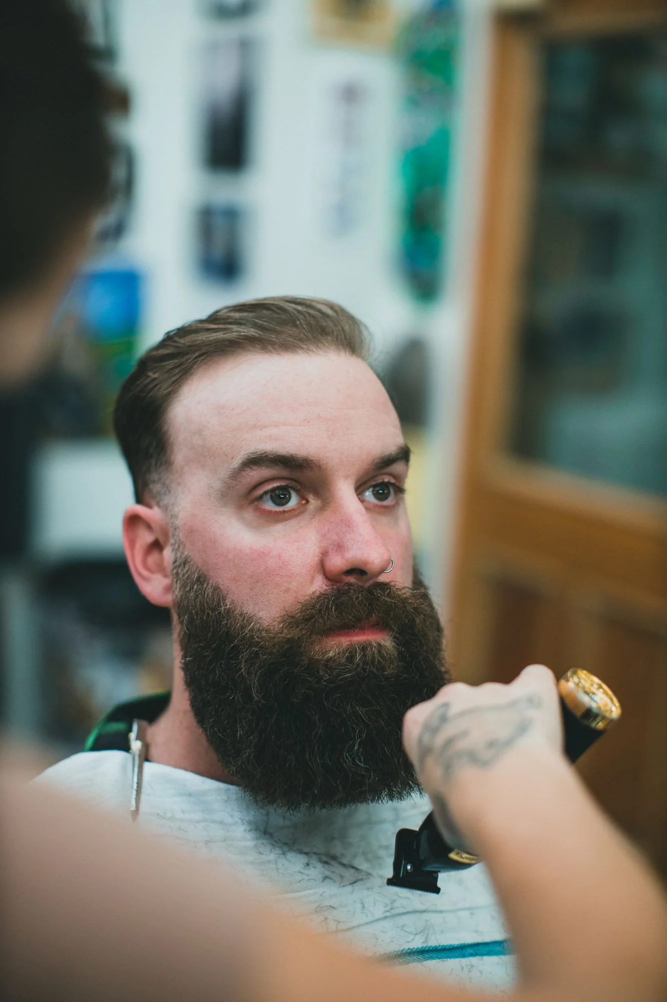 A barber shapes the outline of a full beard