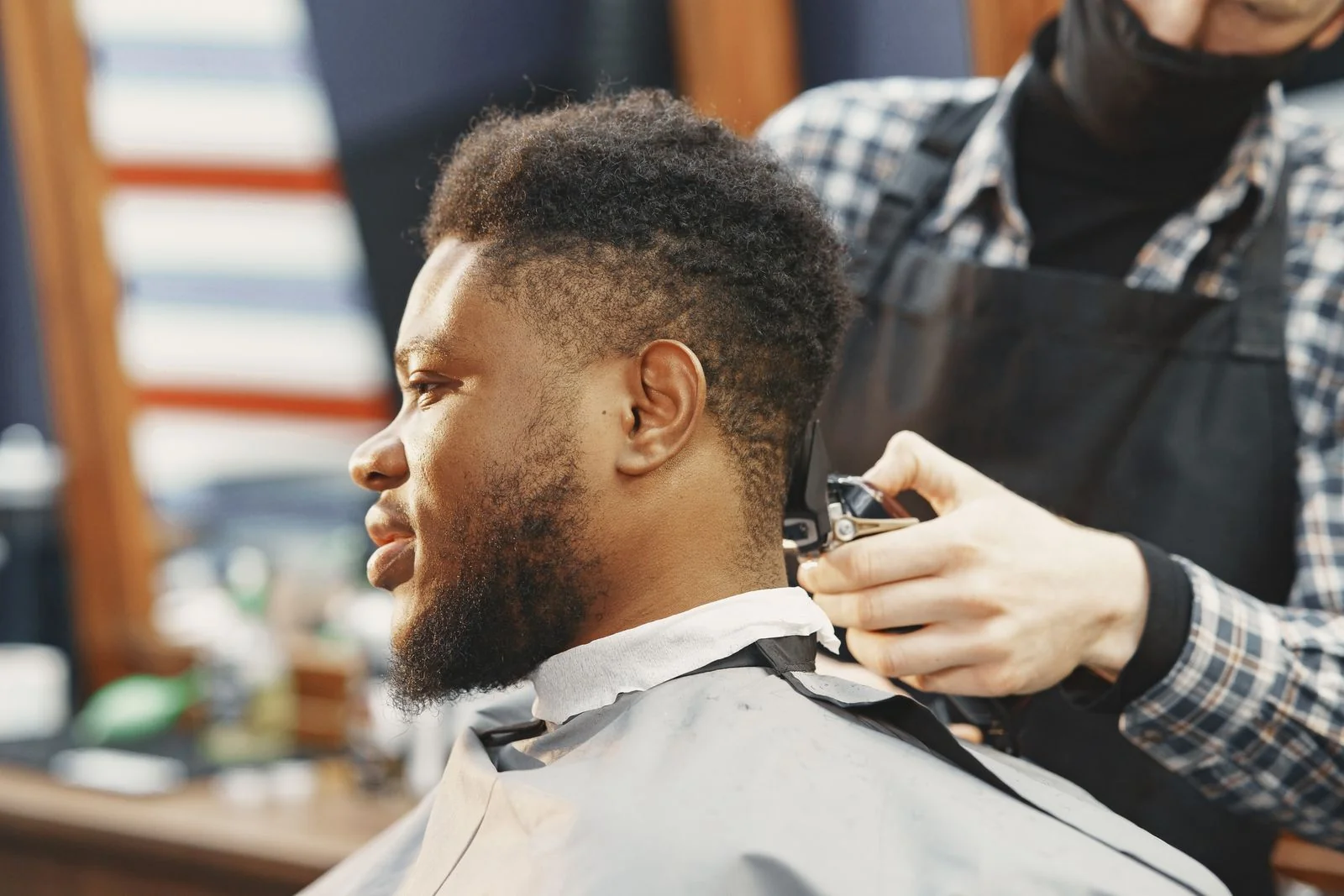 Barber refining the neckline of a short textured haircut