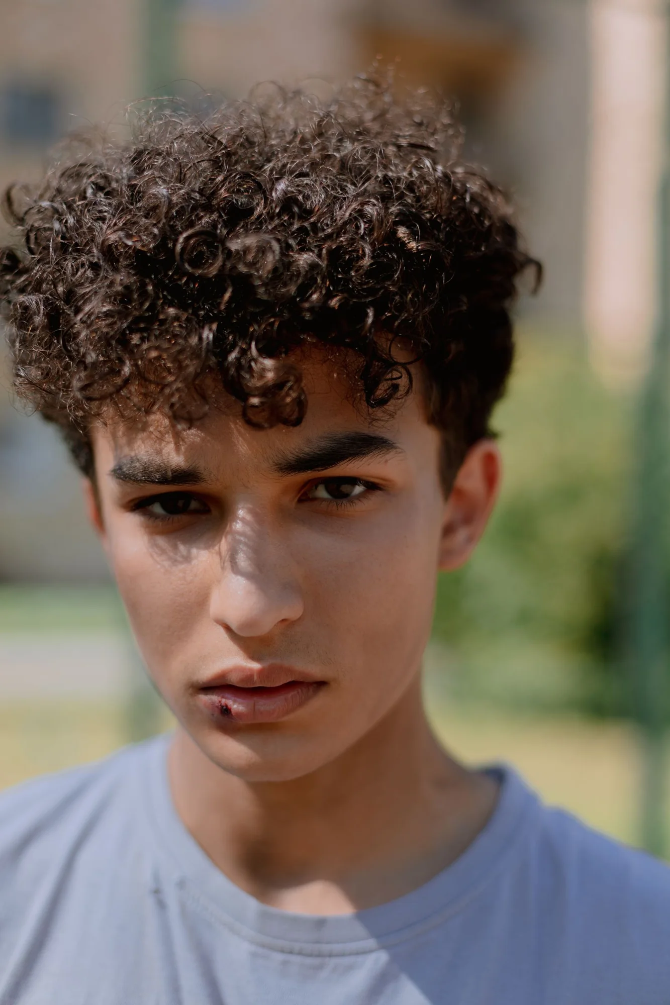 Portrait showing a full curly top and shorter sides