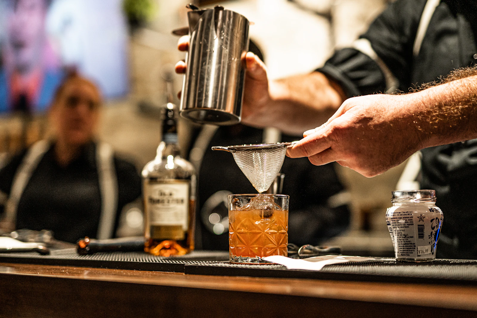 A cocktail strained into a glass at the bar