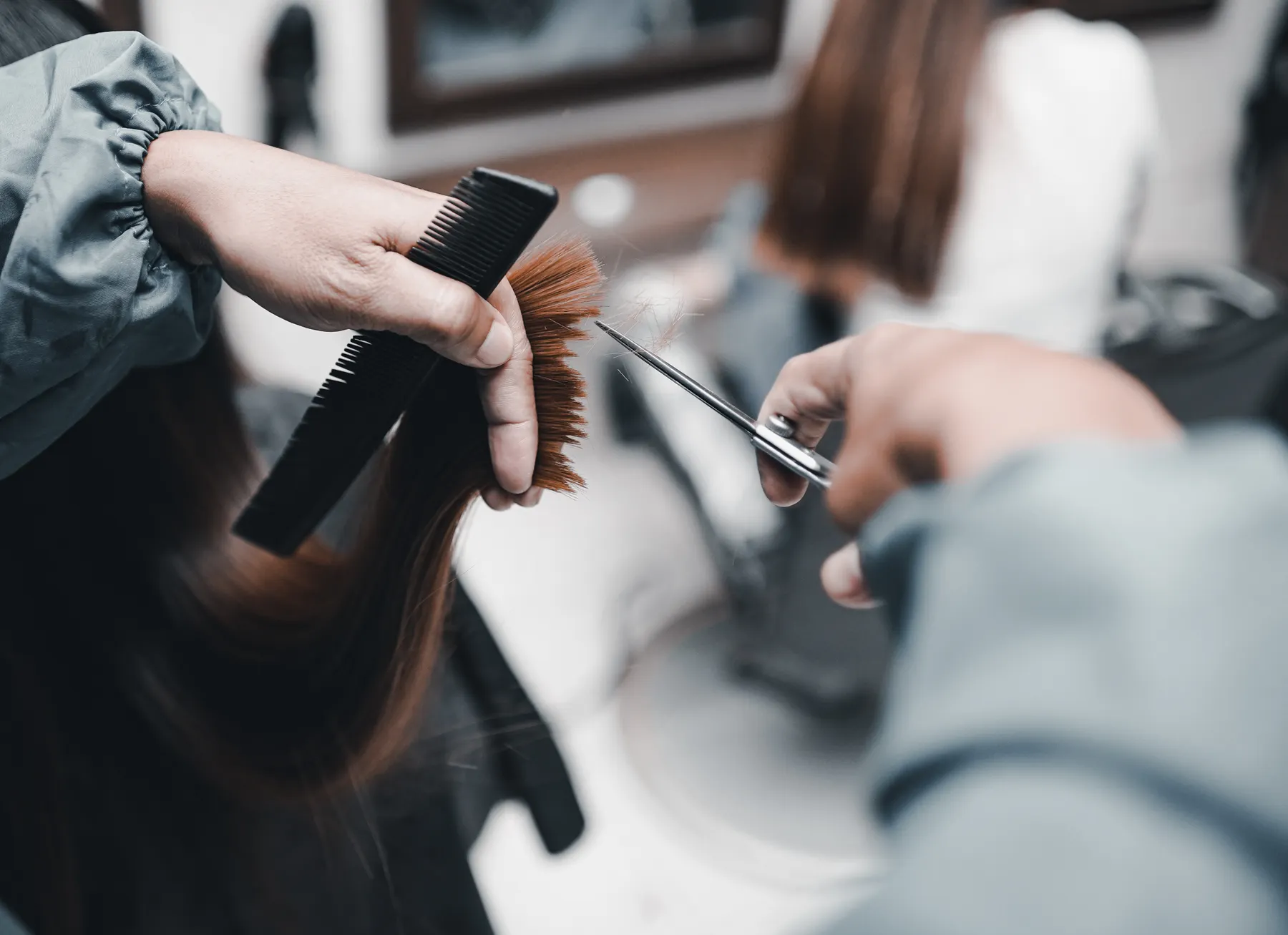 Hands shaping a haircut with scissors and a comb