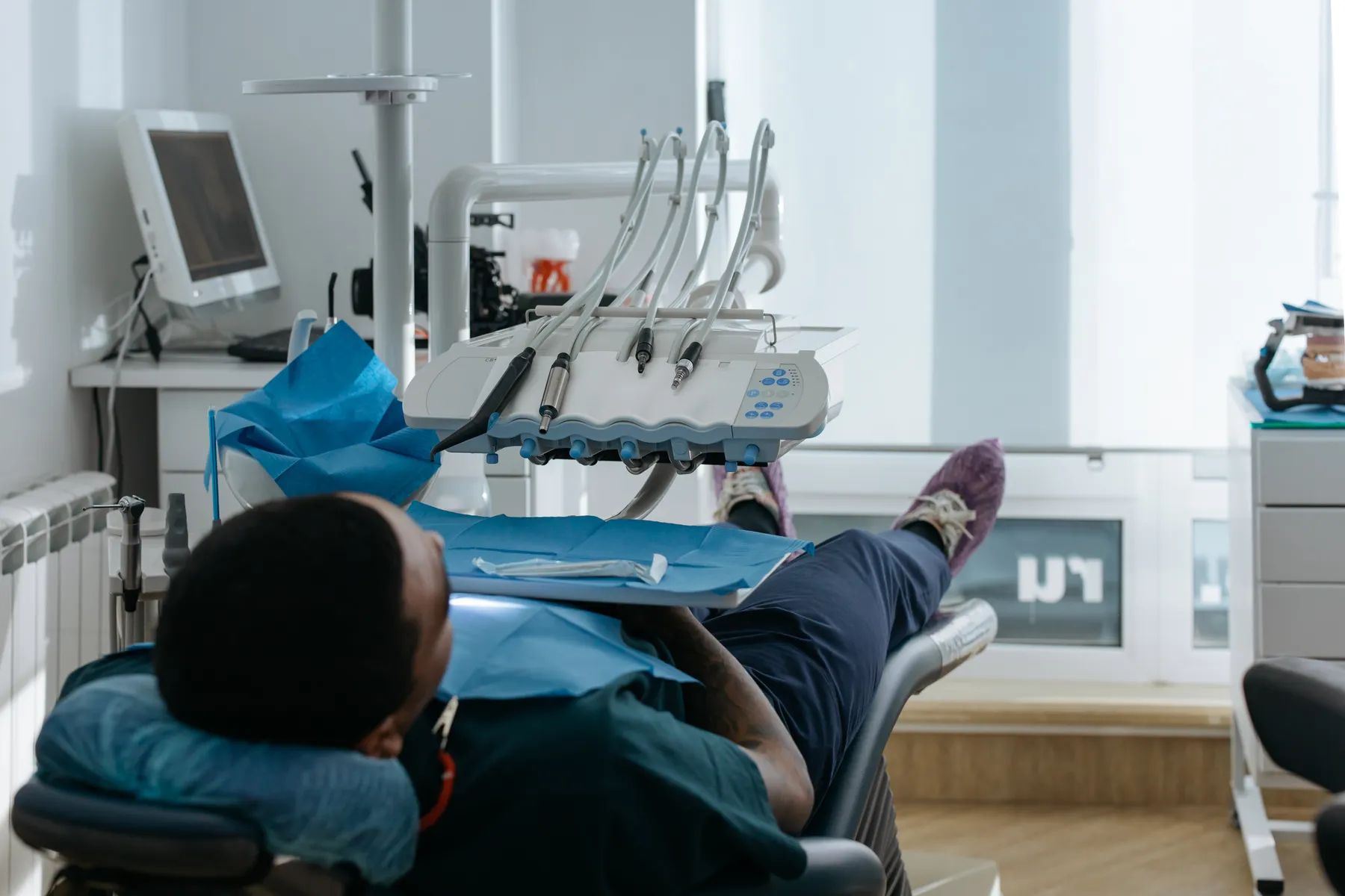 Patient reclining in a dental chair surrounded by treatment equipment