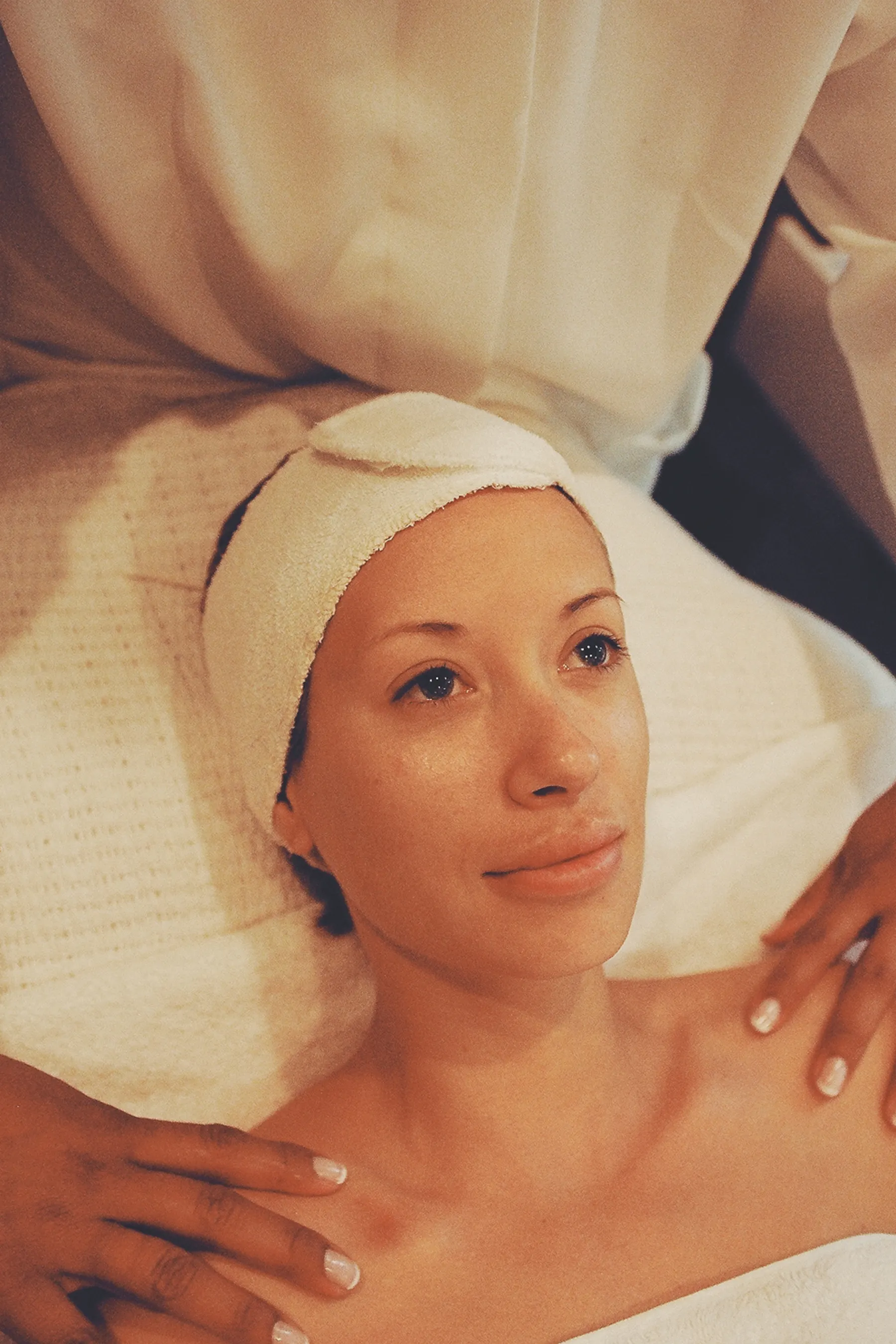 Woman resting during a shoulder and neck massage with a towel headband