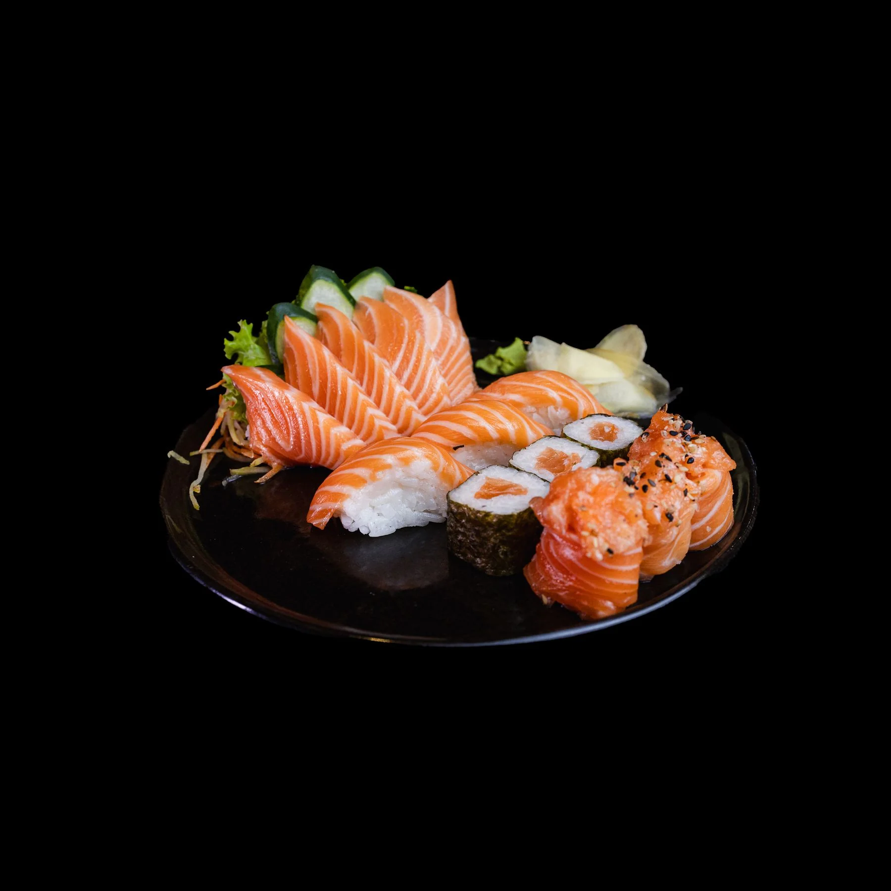 Salmon sashimi, nigiri and maki on a black platter
