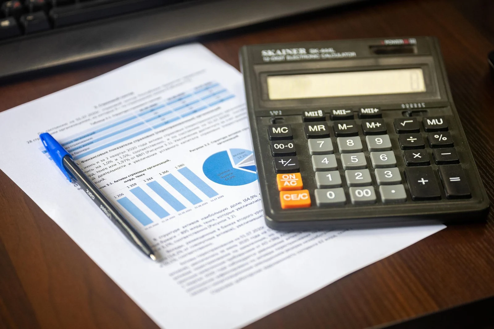 Calculator and financial report on a wooden desktop