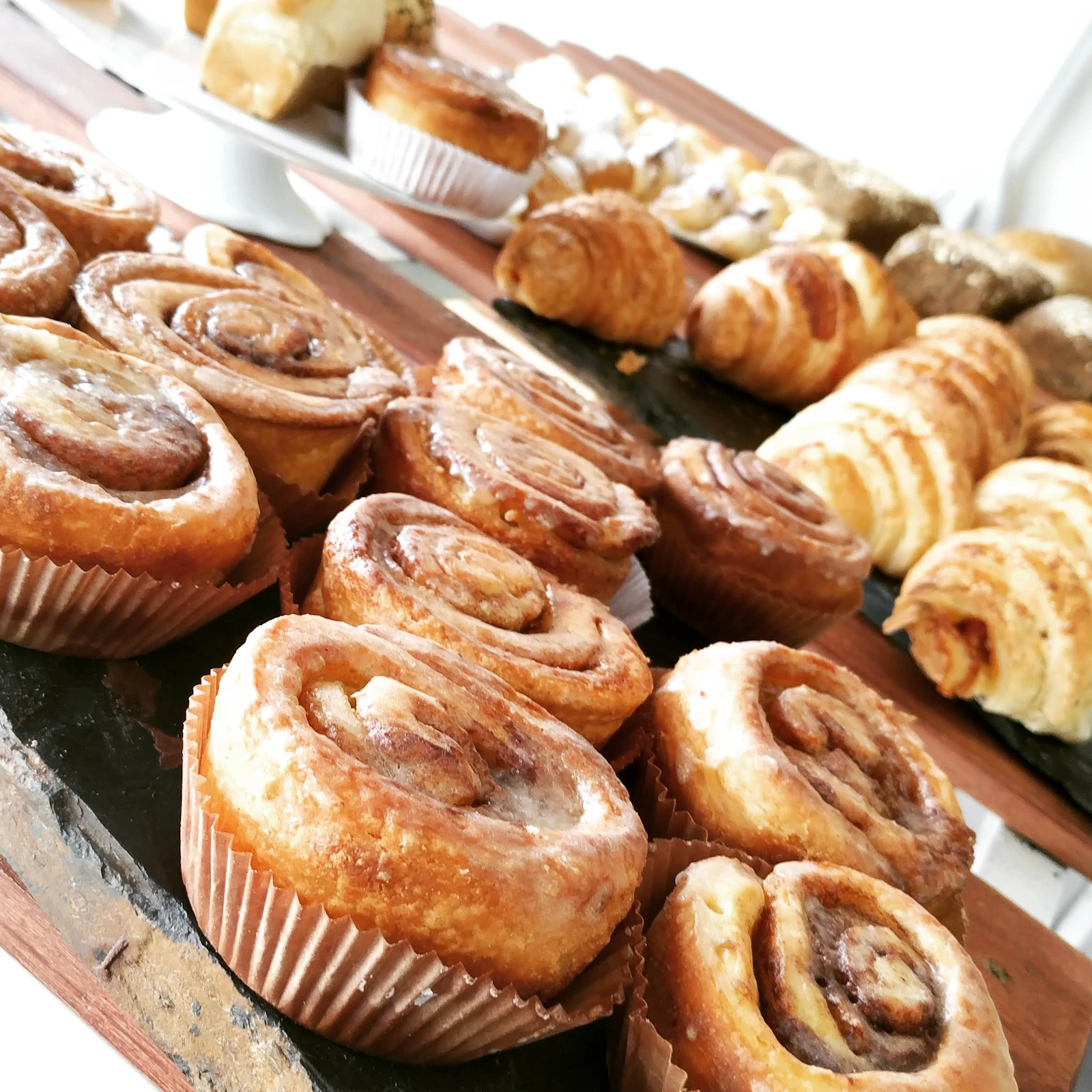 Cinnamon rolls and croissants at a bakery counter