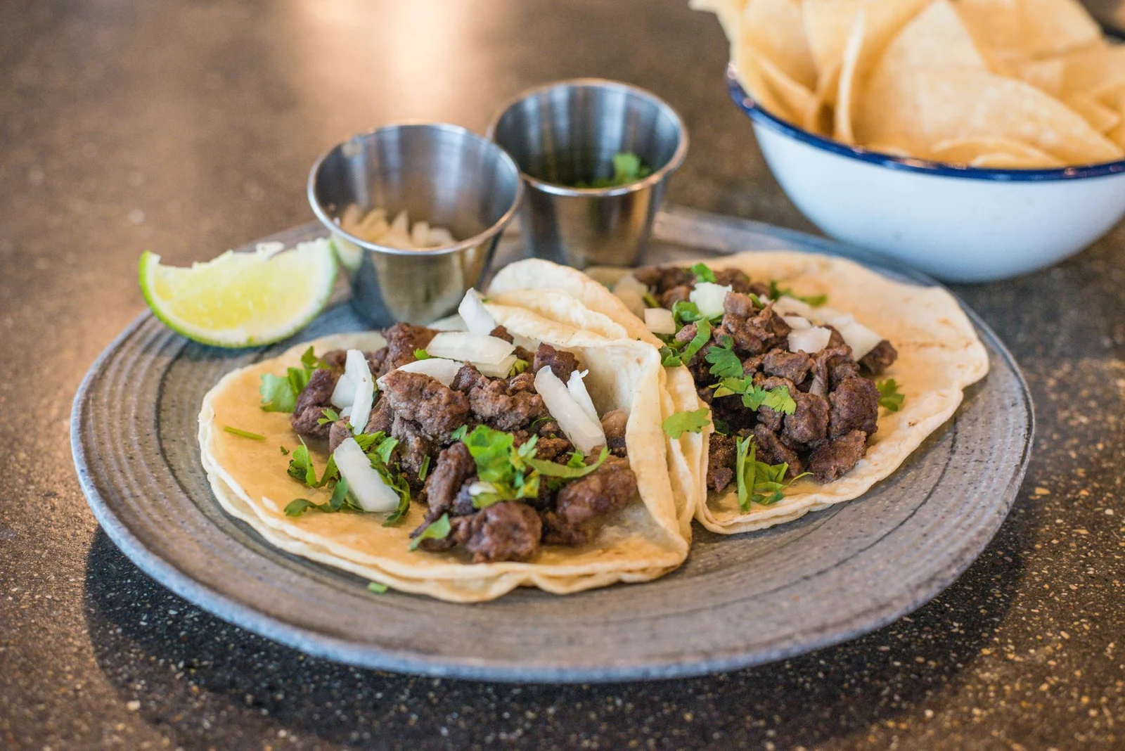 Steak tacos with onion, cilantro, lime and salsa